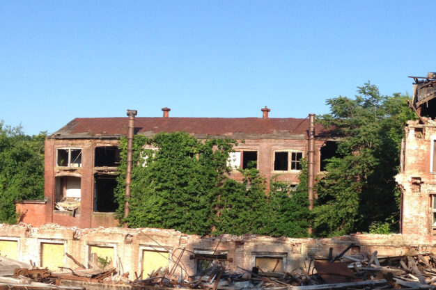 Image of dilapidated multi-story brick factory.